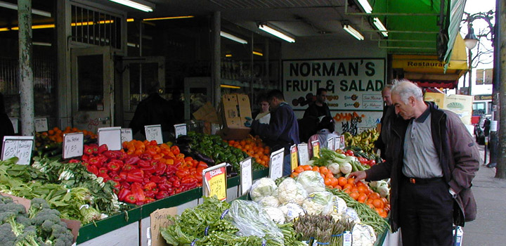 Man looking at oranges at fruit and vegetable stand