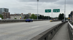 Cars on Georgia Viaduct near signs for Prior St and Main St under cloudy sky