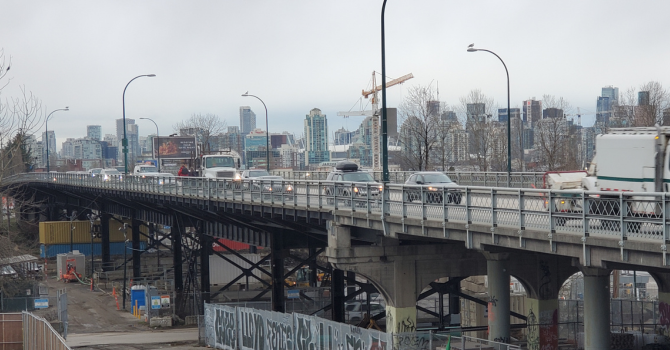 Traffic on the Grandview Viaduct with Vancouver skyline and construction cranes in the background