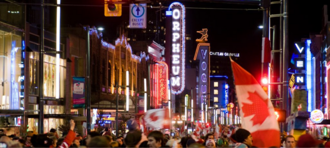People on Granville Street at night holding Canadian flags People on Granville Street at night holding Canadian flags