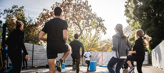 Outdoor fitness class featuring participants jogging in place