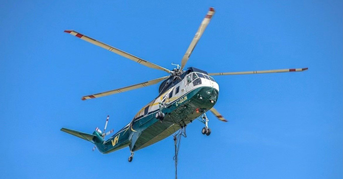 A helicopter in flight with bright blue sky in the background