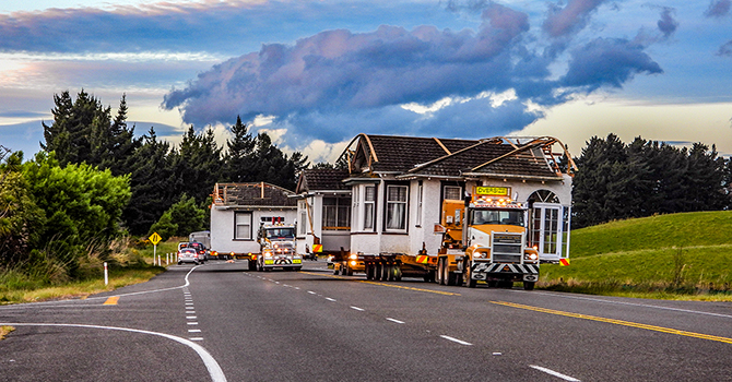 A white house on a truck being relocated