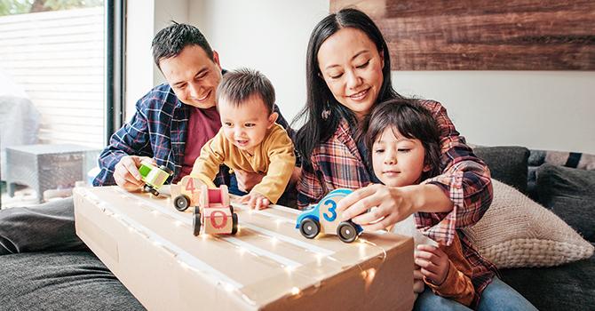 A couple playing with their young children at home