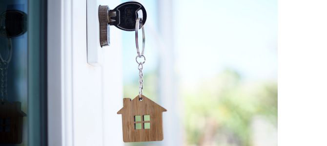 Key in a door lock with a house-shaped keychain