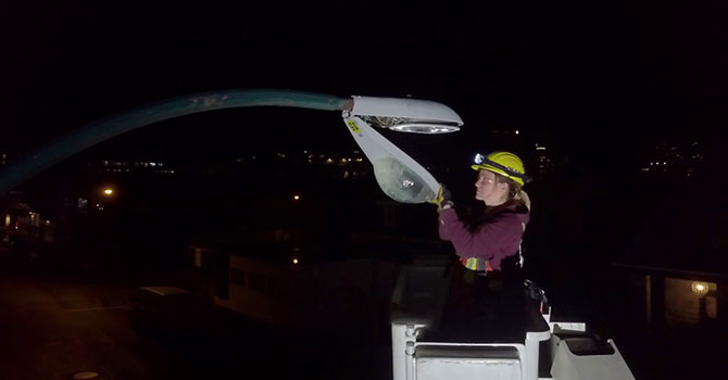 A worker replaces a burnt out street light