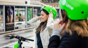 A women wearing a Lime e-scooter helmet smiling