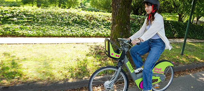 Person riding a Mobi by Rogers e-bike with helmet on a sunny day Person riding a Mobi by Rogers e-bike with helmet on a sunny day