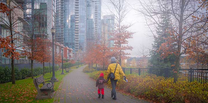 Woman and child holding hands walking downtown