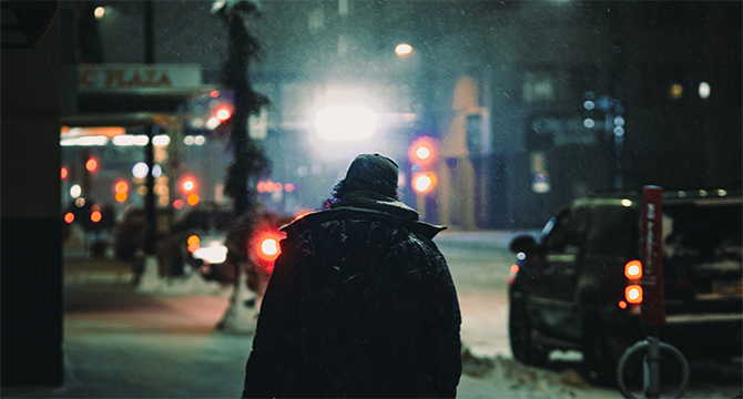 A man walking through the street at night