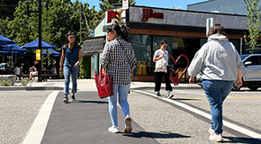 People using a pedestrian crossing at a neighbourhood intersection.
