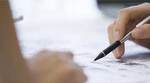 Hand holding a pen on paper