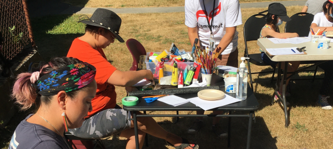 Two people sit outside and work on their art in the sunshine Two people sit outside and work on their art in the sunshine