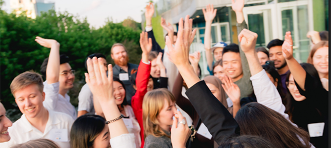 Group of people raising their hands while outdoors