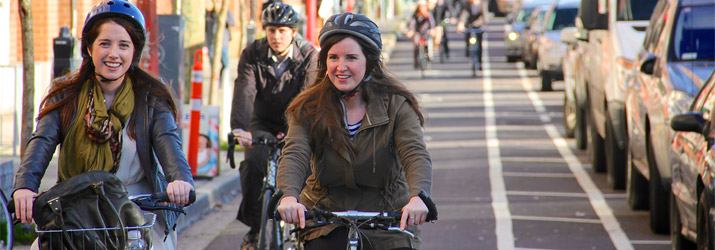 People cycling in bike lane downtown