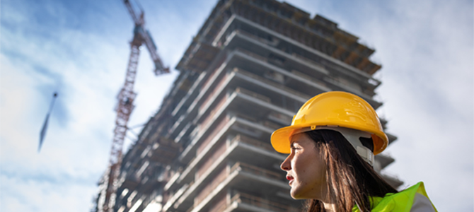 Female construction worker infront of a building