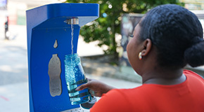 A person fills up a water bottle at a foutain