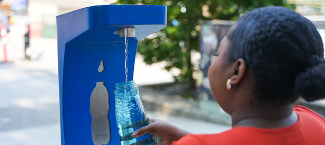 A person fills up a water bottle at a foutain