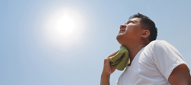 Person suffering from the heat looking at the sun with a towel 