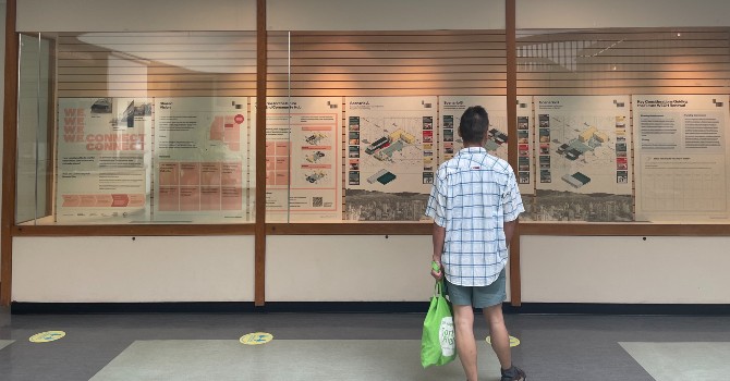 Person standing in front of informaton boards for West End Community Hub Renewal Plan