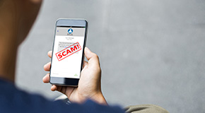 A person holds a phone up with an alert that says 