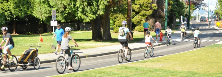 People cycling on the protected bike lane near Point Grey Road at Macdonald Street