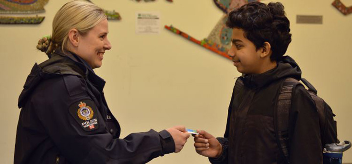 Police officer handing a youth a Positive Ticket Police officer handing a youth a Positive Ticket