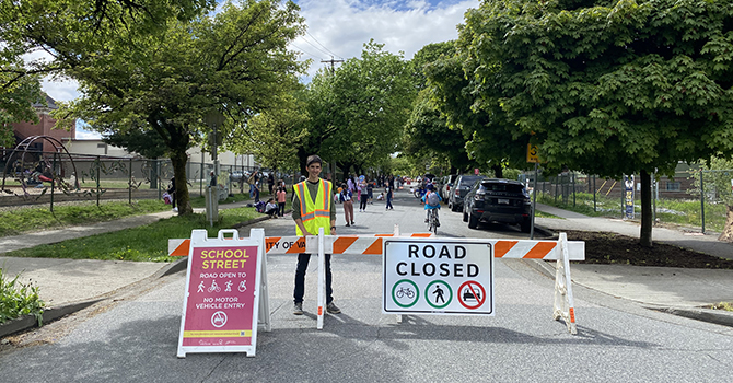 Volunteer standing behind road closure sign