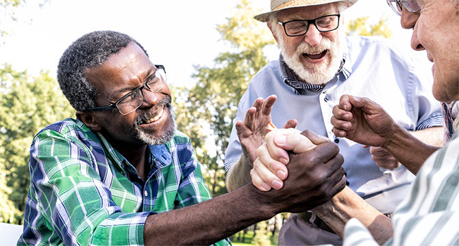 A group of seniors socializing, a couple of them shaking hands