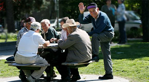 A group of senior men enjoying a board game in a city park