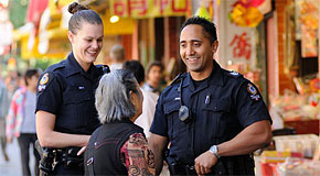 An senior woman speaks with two Vancouver Police officers on patrol in Chinatown