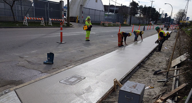 Group of 4 City workers finishing off a new sidewalk