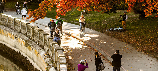 Pedestrians and cyclists using the seawall on a sunny, autumn day