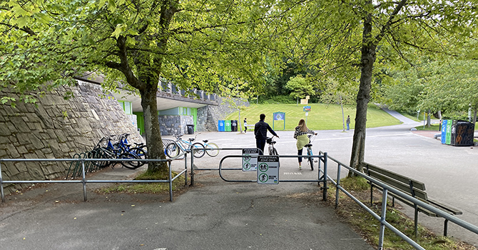 Cyclists passing through speed gates on the Stanley Park Seawall.