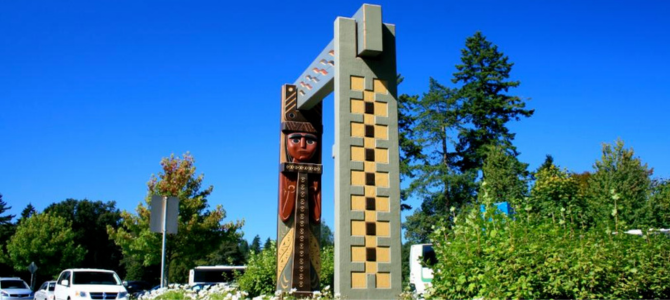 Public artwork by Susan Point featuring a Coast Salish figure and geometric archway. Public artwork by Susan Point featuring a Coast Salish figure and geometric archway.