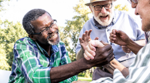 Three seniors laughing together and holding hands