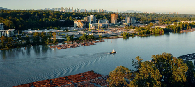 Tugboat in Fraser River with condos along the river in the background.