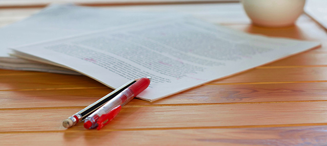 A document and pens on a wooden table