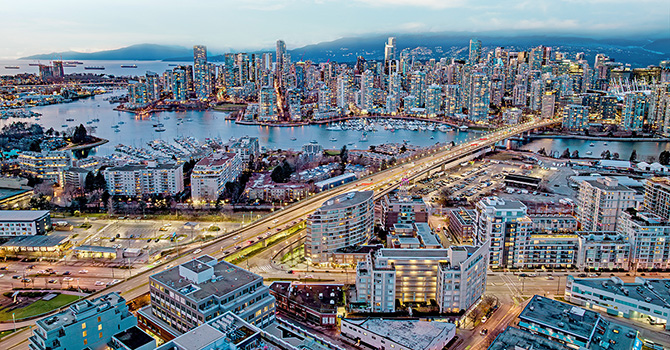 Aerial view of downtown Vancouver at dusk with False Creek, Granville Bridge, and city skyline
