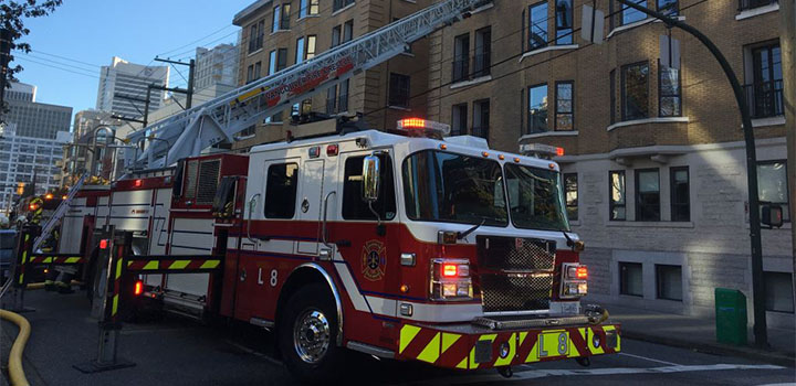 A firetruck with its ladder extended in front of a building