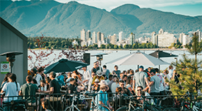 People sitting at a patio in front of the mountains in Vancouver's Kits neighbourhood