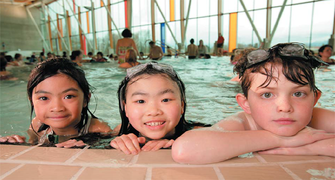 Three primary school-aged children swimming at Hillcrest Pool