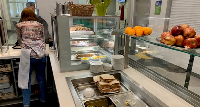 A volunteer in the Carnegie kitchen serving food