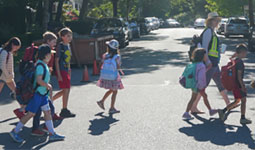 Children and adult walking across street