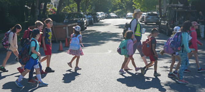 Children and adult walking across street