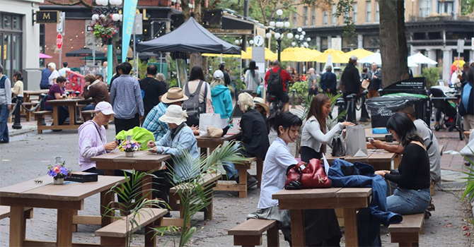 People sitting and eating outdoors in Vancouver's Gastown