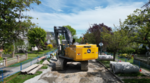 A excavator digging up a roadway