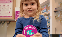 Child holding a Future Voters sticker