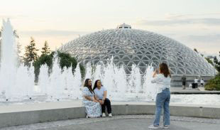 Two people posing for a photo near the fountains outside the Bloedel Conservatory.
