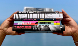 Hands holding a stack of Vancouver Book Award books